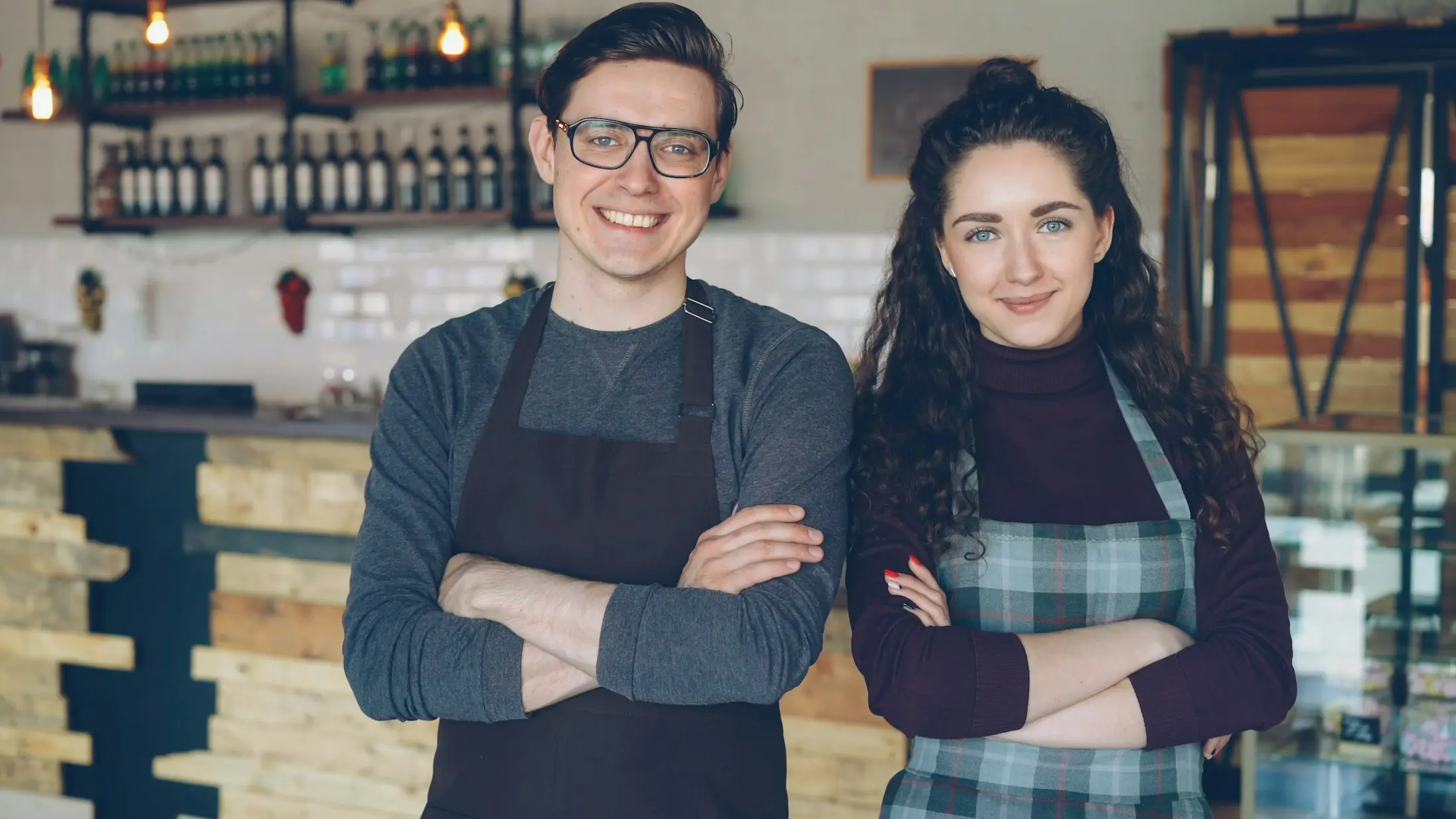 Two café owners standing proudly behind their counter