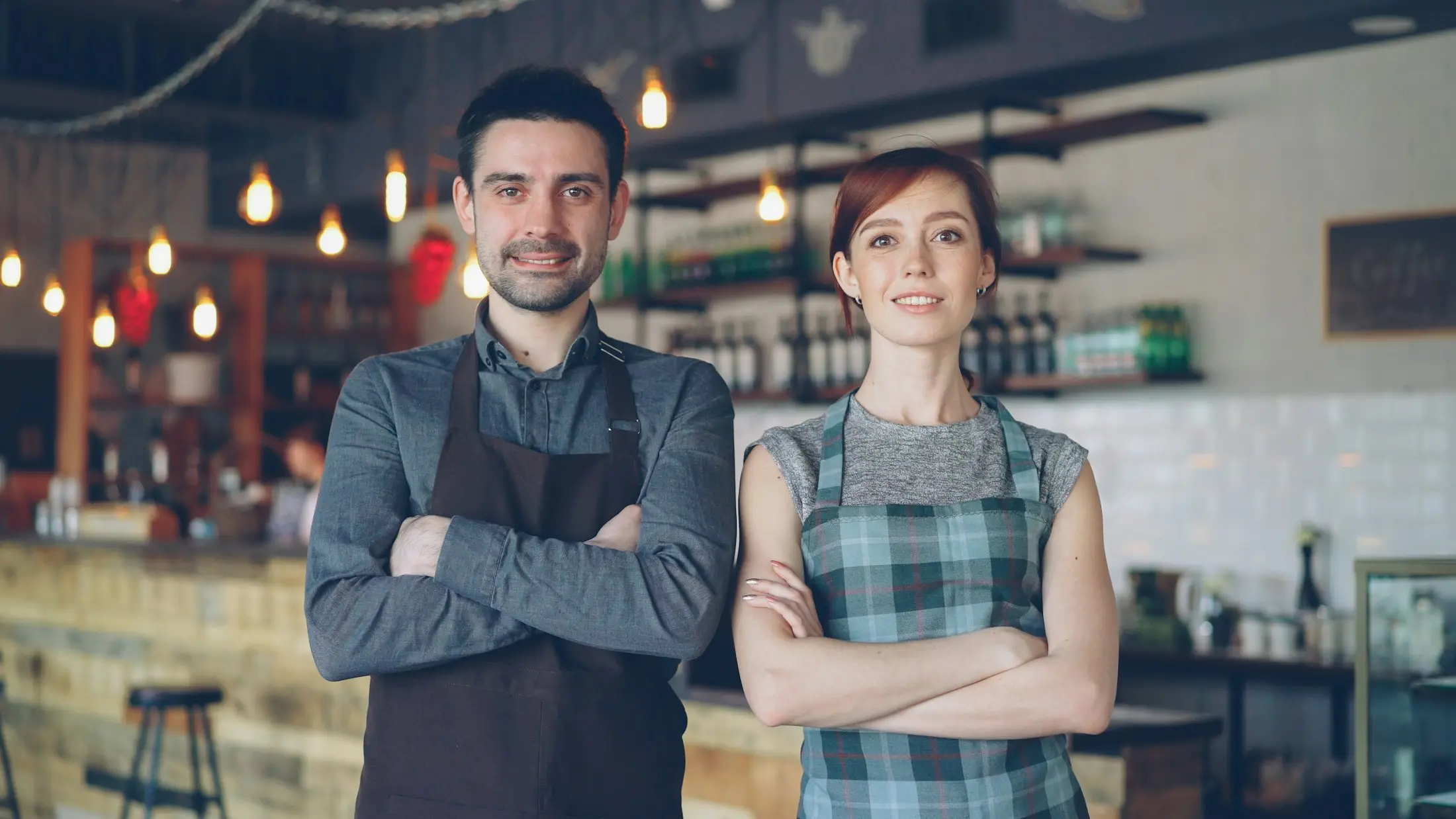 Two café co-owners standing proudly side by side inside their newly opened café