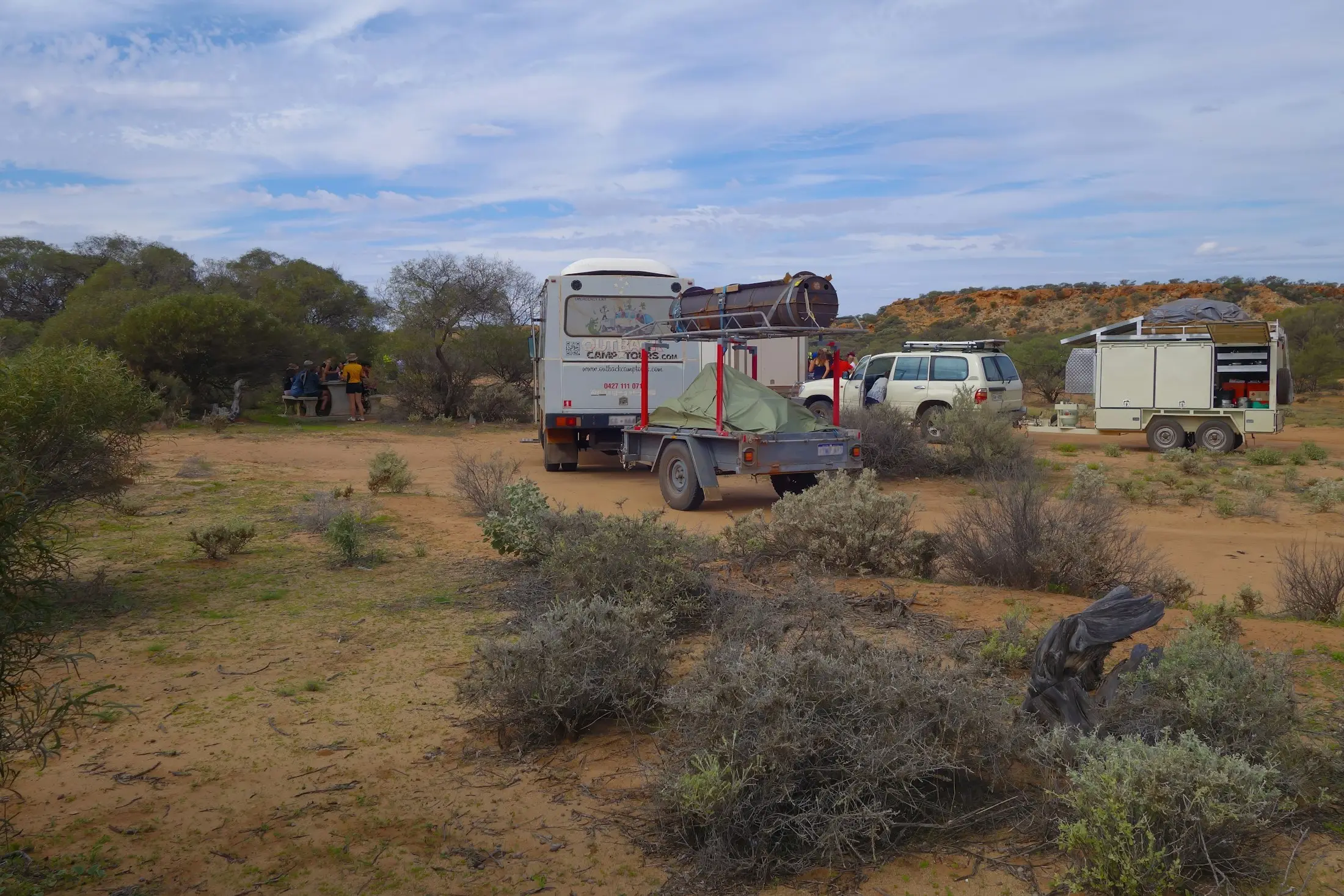 Caravan and camper set up at an outback camp among saltbush