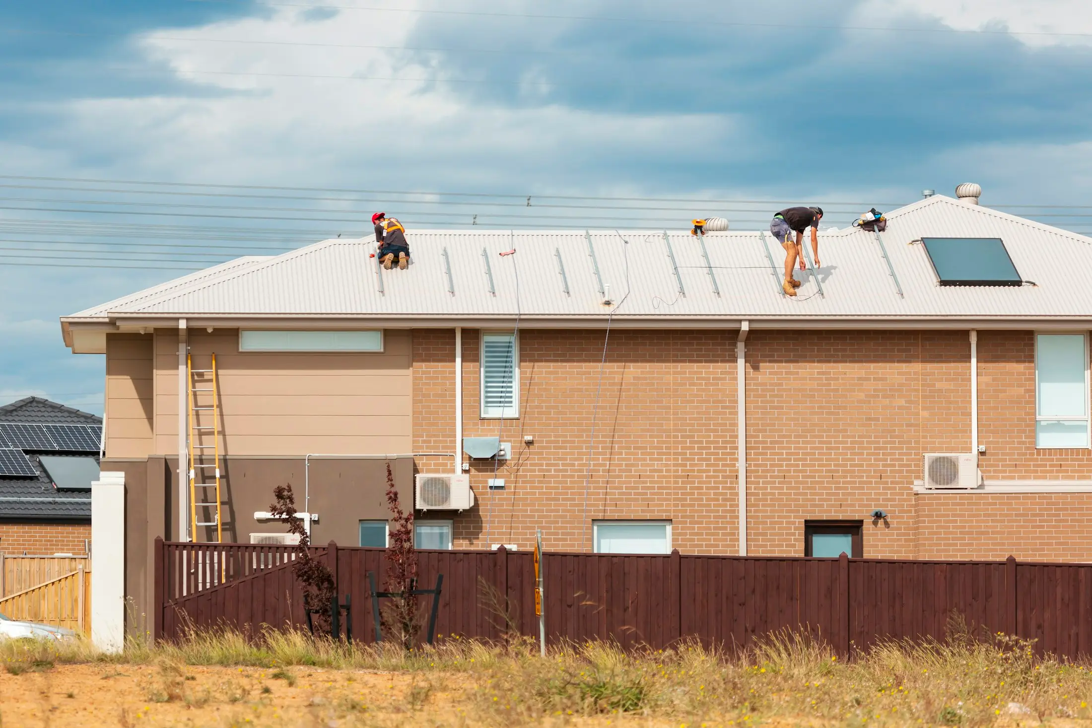 New brick home in Victoria with solar panels across the roof under a blue sky