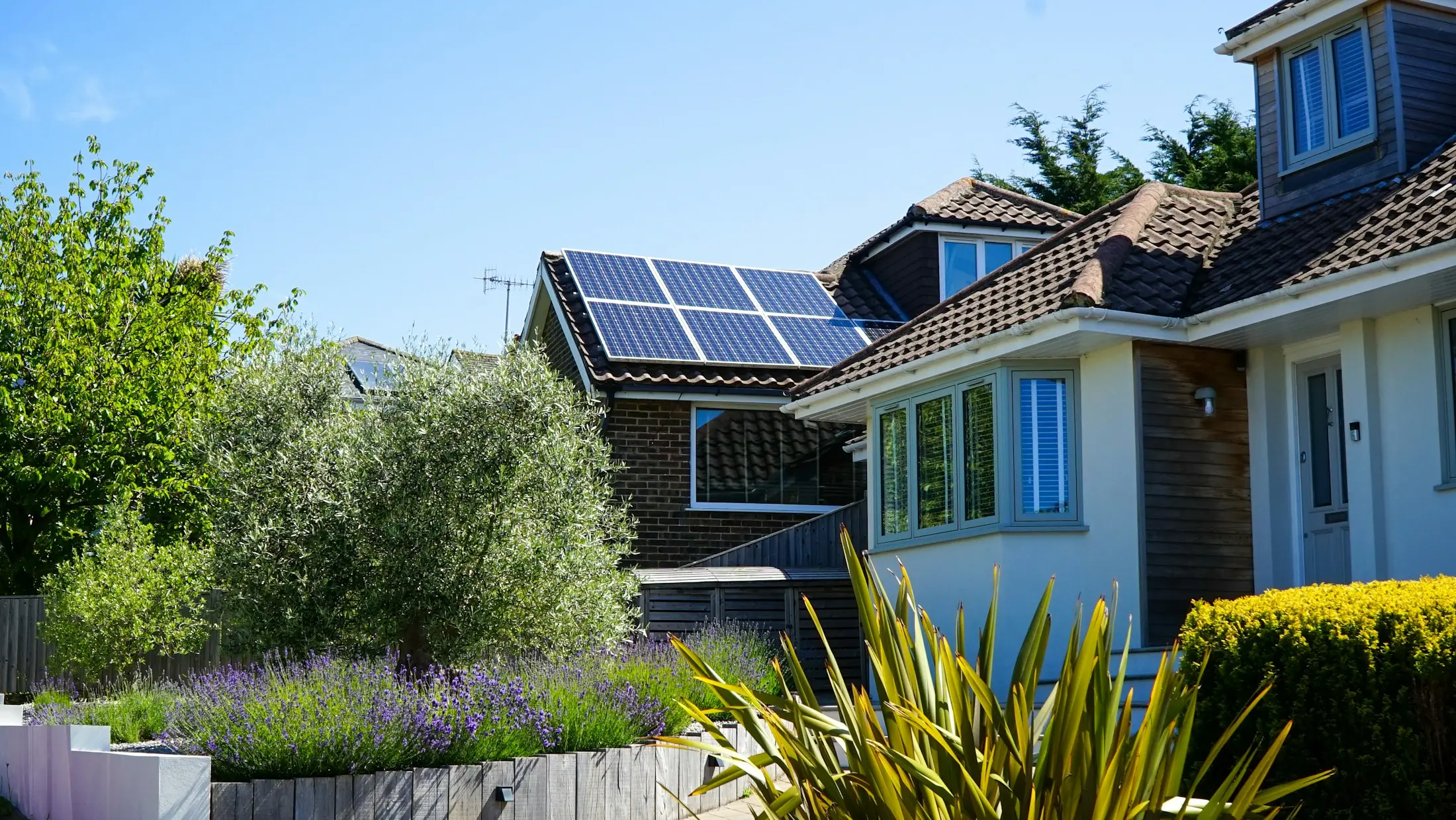 Suburban house with solar panels on the roof in the midday sun