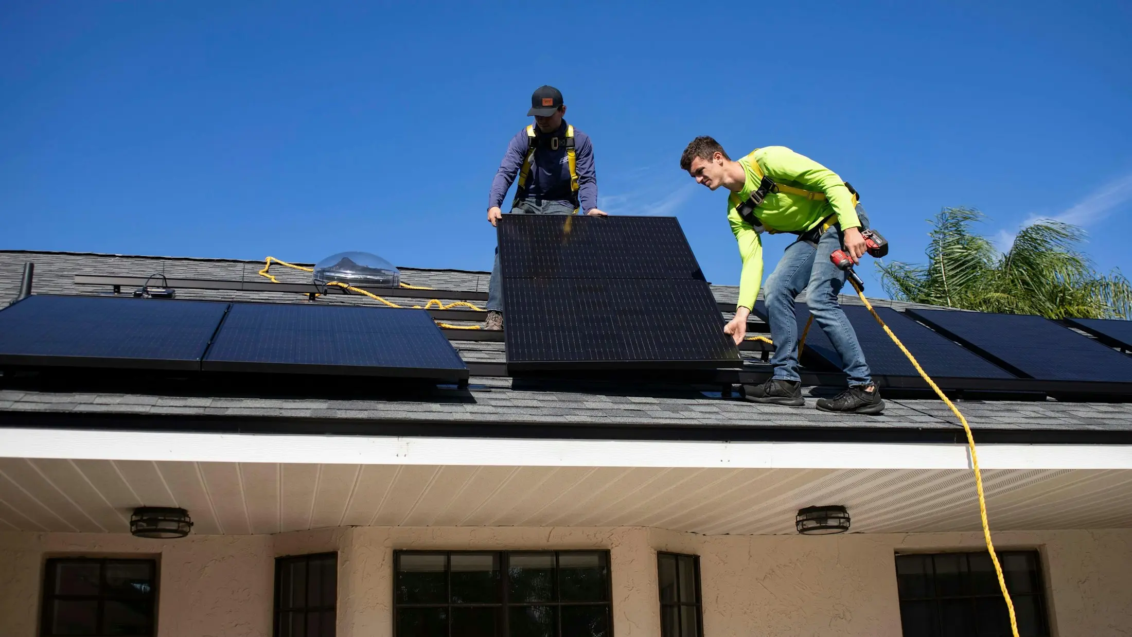 Installers fitting rooftop solar panels on an Australian home