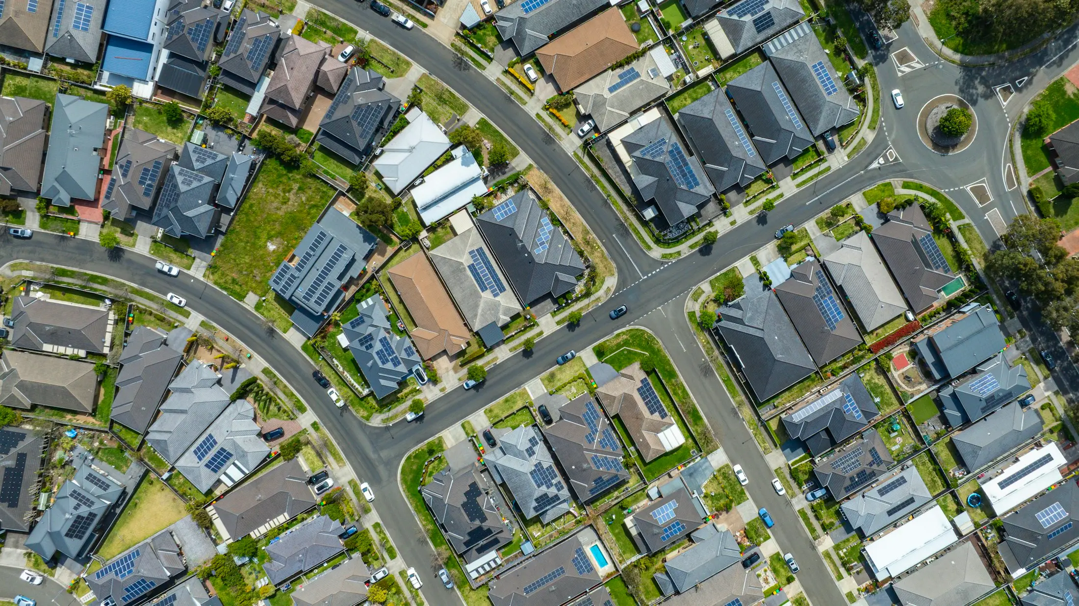 Aerial view of a suburb with solar panels across many rooftops
